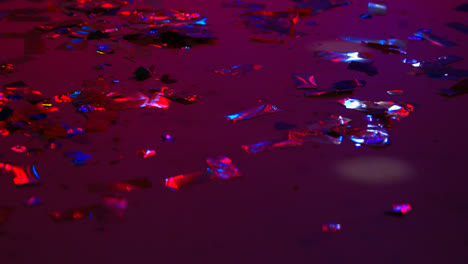 Close-Up-Of-Sparkling-Confetti-On-Floor-Of-Nightclub-Bar-Or-Disco-With-Flashing-Strobe-Lighting